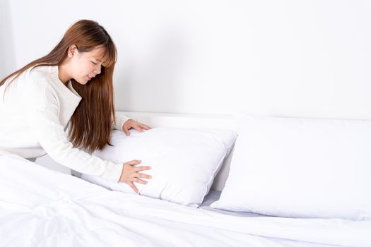 Beautiful Asian women making bed in room early in the morning. daily life concept.