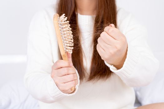 Hair fall problem, closeup hand holding comb and problem hair. Healthcare medical or daily life concept.