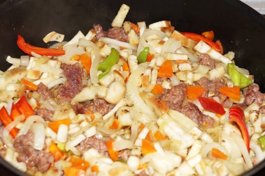 vegetable stew with meat and sour cream in a saucepan close up