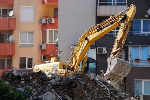 Varna, Bulgaria - August, 04,2020: excavator demolishes a house in a residential area