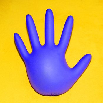 inflated rubber medical glove on yellow background, square photo for instagram