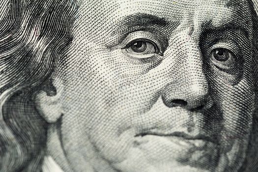 A close view of engraving portrait of Ben Franklin of old one hundred us dollars banknote. Selective focus with natural lens blur.