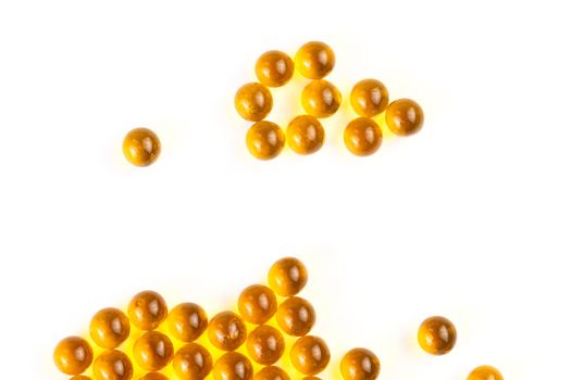 orange spherical ball capsules of fish oil selective focus isolated on white background.