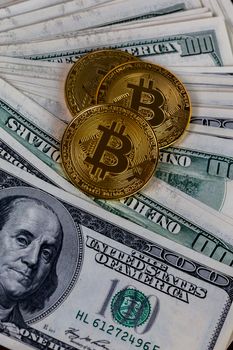 three bitcoin shiners on paper us dollar banknotes background.