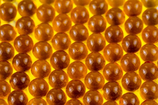 orange spherical ball capsules of fish oil selective focus background.