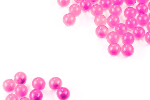 plastic pink spherical ball capsules with selective focus isolated on white background.