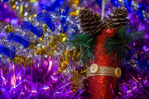 Christmas holidays composition with red gliter cone in colored tinsel - close-up with selective focus an bokeh