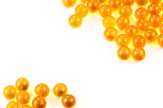 orange spherical ball capsules of fish oil selective focus isolated on white background.