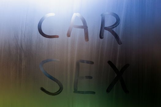 the words car sex written by finger on sweaty window glass - close-up in horizontal orientation