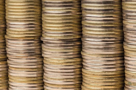 Five equal stacks of coins merged in one solid wall macro background.