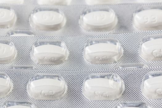 white tablets in blister closeup with selective focus.