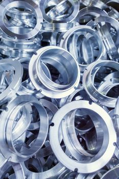 a batch of machined shiny metal parts with selective focus.