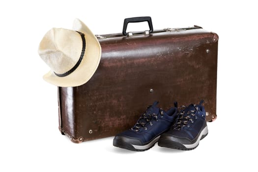 old brown fiber suitcase with hat and sneakers isolated on white background.