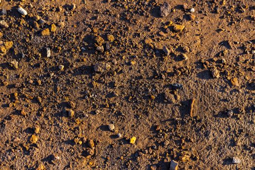 abstract dry mud background with small rocks and selective focus.