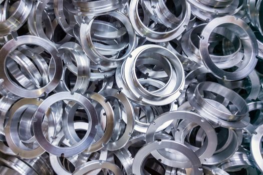 a batch of machined shiny aluminium parts with selective focus.