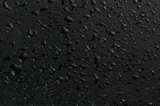 water drops on black flat rubber surface dark macro background