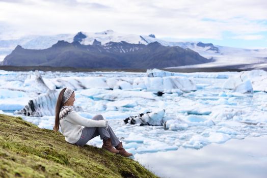 Iceland tourist enjoying Jokulsarlon glacial lagoon. Woman visiting destination landmark attraction glacier lake, Iconic Vatnajokull nature landscape.