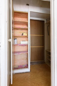 Old wardrobe in the interior of an apartment hallway with an outdated poor interior