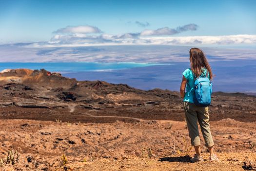 Galapagos tourist on adventure hiking looking at view on volcano Sierra Negra on Isabela Island. Woman on hike visiting famous landmark and tourist destination, Galapagos Islands Ecuador