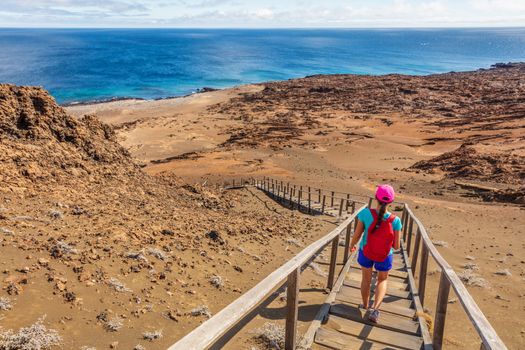 Galapagos tourist hiking enjoying famous Bartolome Island. Travel vacation adventure woman on hike to viewpoint and visitor site of landscape.