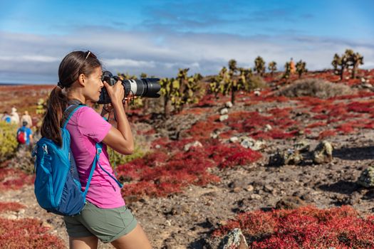 Galapagos tourist taking pictures of wildlife, landscapes and animals on North Seymour, Galapagos Islands. Amazing animals and wildlife during Galapagos cruise ship vacation travel