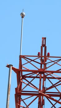 Telecommunication tower closeup and red color and sky.