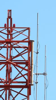 Telecommunication tower and red color and blue sky.