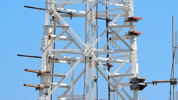 Telecommunication tower closeup and white color and sky.