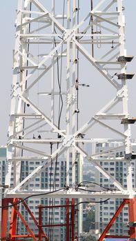 Telecom tower closeup with white color and blue sky.