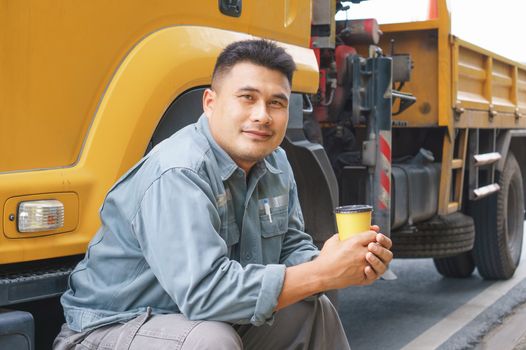 Smile is confident that the truck driver is a mature Asian professional in the transportation and delivery business.