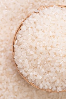 Raw rice in a bowl and full frame in the white background table, top view overhead shot, close up