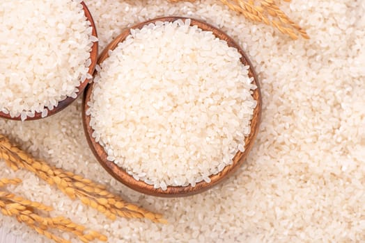 Raw rice in a bowl and full frame in the white background table, top view overhead shot, close up