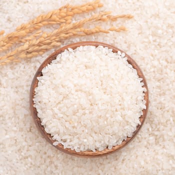 Raw rice in a bowl and full frame in the white background table, top view overhead shot, close up