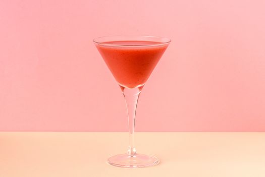 Strawberry smoothie cup on a pink and yellow background. Minimalist image.