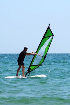 old man windsurfing in the sea