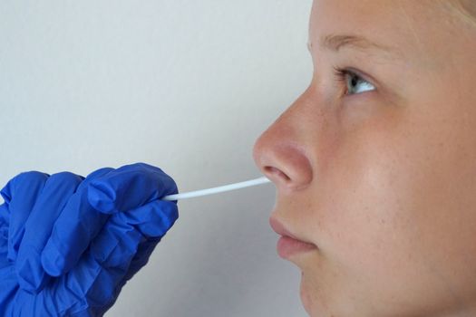 the doctor takes a test for coronavirus from the girl's mouth.