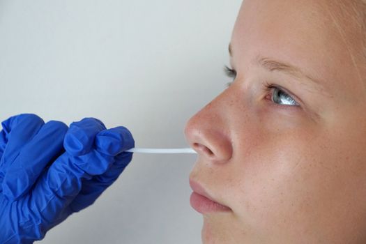 the doctor takes a test for coronavirus from the girl's mouth.