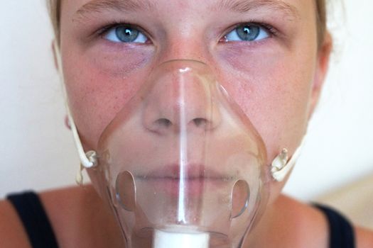 girl breathing through an inhaler, portrait close up