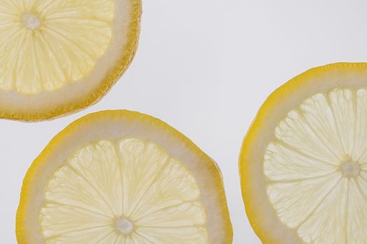 Fresh yellow lemon slices against a white isolated background