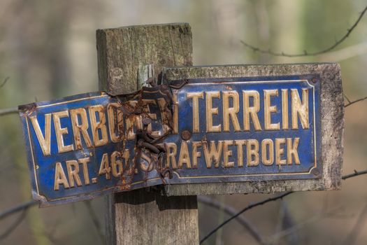 Old weathered sign forbidden entry in Dutch language on a pole