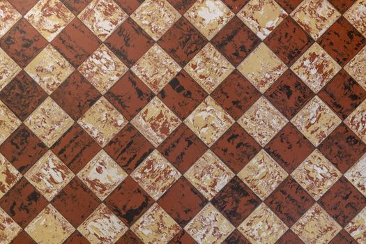 Old-fashioned antique brown beige floor tiles in a characteristic old farmhouse in the Netherlands as a full-screen background photo.