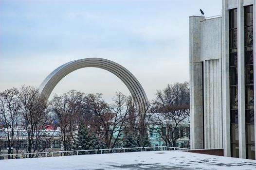 The Peoples' Friendship Archis a monument in Kiev, the capital of Ukraine.Here seen in winter with snow and gray cloudy sky.