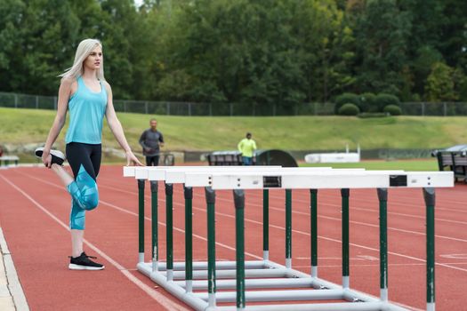 A beautiful young college athlete prepares herself for a track meet at a local university