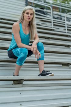 A beautiful young college athlete prepares herself for a track meet at a local university