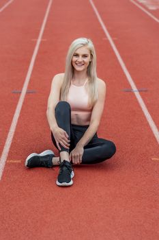 A beautiful young college athlete prepares herself for a track meet at a local university
