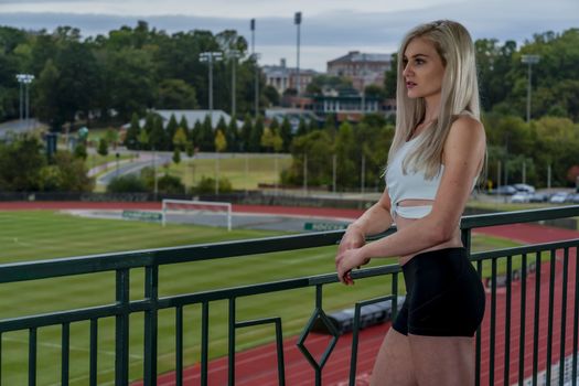 A beautiful young college athlete prepares herself for a track meet at a local university