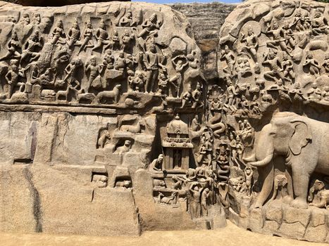 A giant open air rock cut bas relief sculptures carved on two monolithic rocks in Mahabalipuram, Tamil nadu. It contains sculptures of animals, God, People and half-humans.