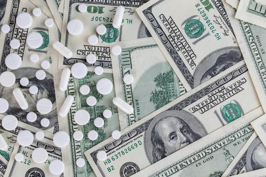 pills flat background, tablets on a us dollar banknotes - top-down view.