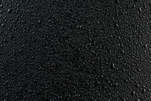 water drops on flat black rubber surface dark macro background