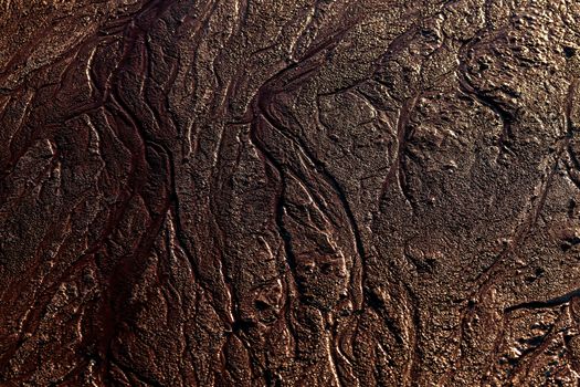 abstract mud background with water washout trails and selective focus.